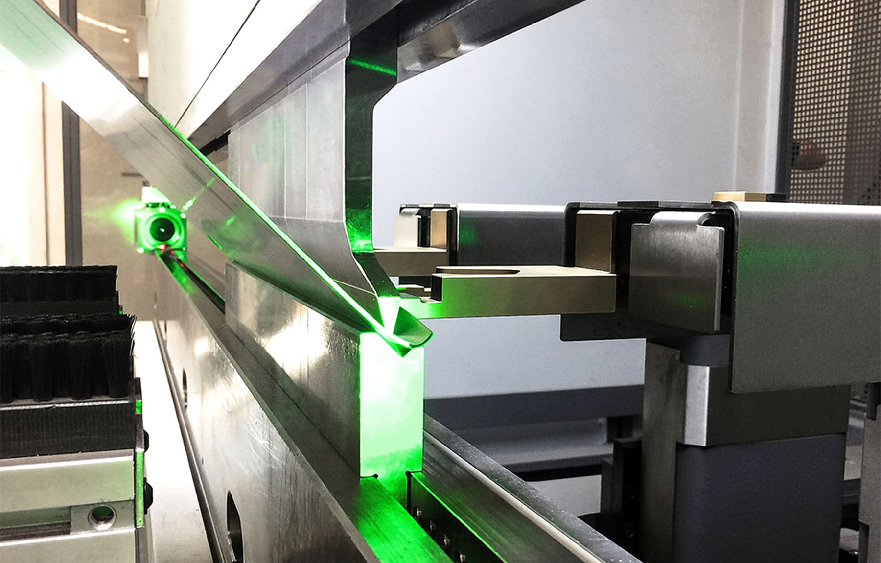 Abkantpresse im Betrieb, Blech im Werkzeug, Laserlinie auf der Kante